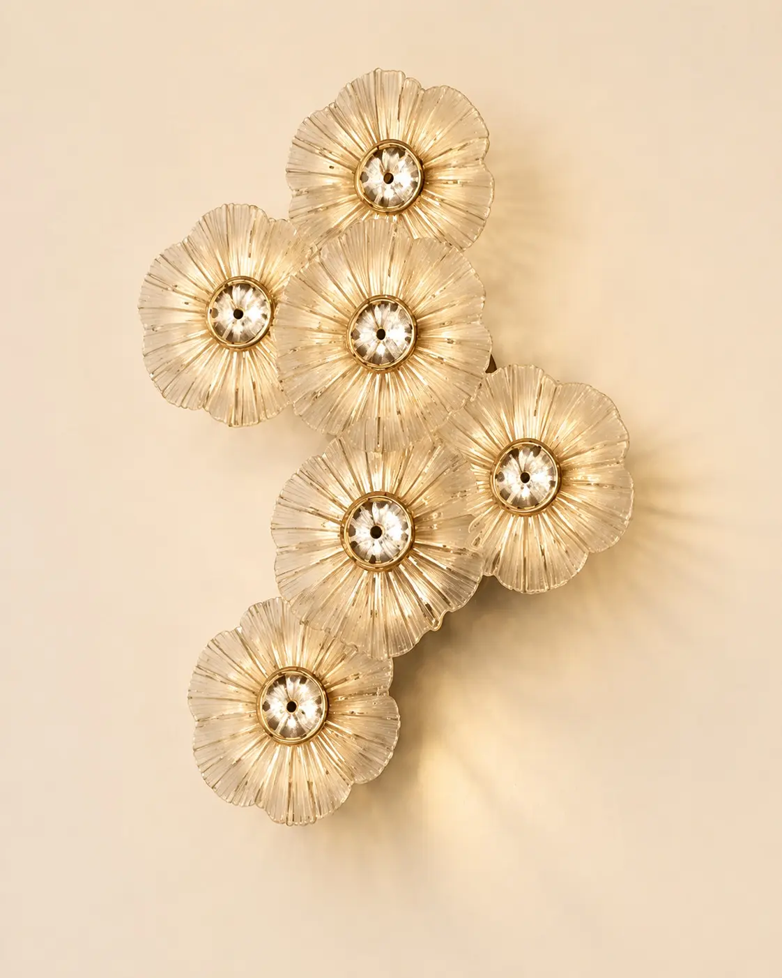 Sculptural floral wall light in warm gold and glass